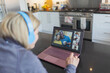 © Paul Bradbury/Caia Image - Woman with headphones and laptop video chatting with friends