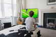 © Paul Bradbury/Caia Image - Boy watching soccer match on TV in living room