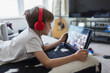 © Paul Bradbury/Caia Image - Boy with headphones and digital tablet homeschooling