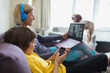 © Paul Bradbury/Caia Image - Mother and son using laptop and smart phone on sofa