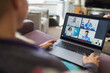 © Paul Bradbury/Caia Image - Woman with laptop video chatting with doctors from sofa