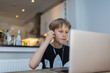 © Paul Bradbury/Caia Image - Boy with headphones homeschooling at laptop