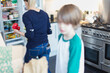 © Paul Bradbury/Caia Image - Mother and son unloading groceries in kitchen
