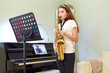 © Adam Gault/Caia Image - Girl taking online saxophone lesson at home