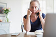 © Sam Edwards/Caia Image - Woman working from home talking on telephone