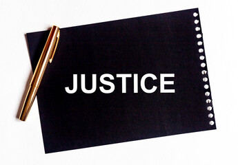 justice word written on black paper on office table, flatly