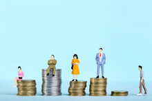 Miniature People With Stacks Of Coins On Blue Background