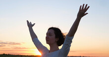 Female Practicing Qigong In Summer Fields With Beautiful Sunset On Background	