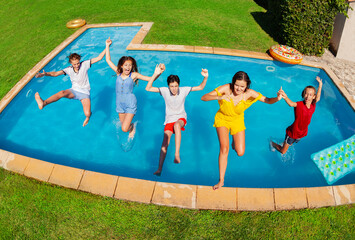 Wall Mural - View from above of the kids in casual clothes fall down to the pool together holding hands