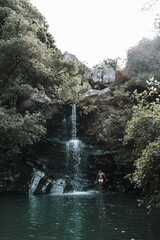 Sticker - Young Caucasian male having a fun time at a beautiful waterfall near rocks