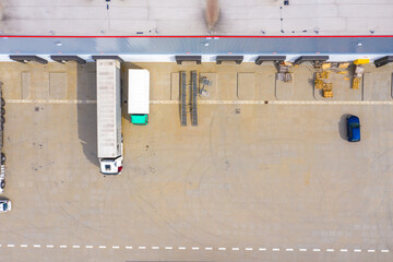 Wall Mural - Aerial view of goods warehouse. Logistics center in industrial city zone from above. Aerial view of trucks loading at logistic center. View from drone.