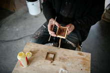 Male Carpenter Using Wood Glue On Piece In Workshop
