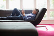 © Tom Merton/Caia Image - Senior man relaxing with digital tablet on living room sofa