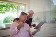 © Tom Merton/Caia Image - Happy senior couple using digital tablet in kitchen
