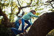 © Paul Bradbury/Caia Image - Father and daughters climbing tree