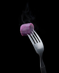 Sticker - Fork with boiled purple sweet potato on black background