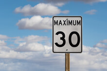 Speed Limit Sign On Blue Sky. Reducing Speeds In Residential Neighborhoods. Safety And Slow Traffic Speed Limits. Road Sign Maximum Speed Posting Copy Space
