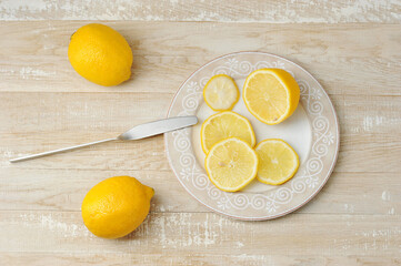 whole and sliced yellow lemons on a plate