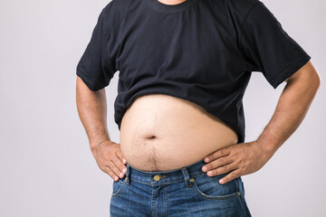 Medical check up concept : Fat people showing his big belly. Used for liver problem or Obesity concept. Studio shot on grey