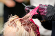 © okskukuruza - Close up shot of hair stylist dying hair of woman with pink dye in hair salon