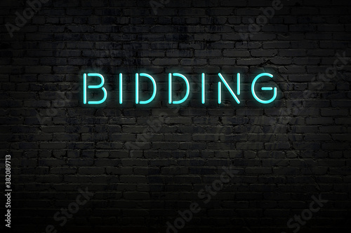 Fotomural Neon sign. Word bidding against brick wall. Night view