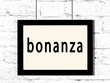 Black frame hanging on white brick wall with inscription bonanza