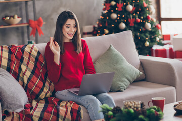 Sticker - Photo of young lovely lady sit sofa hold netbook waving hand wear red sweater jeans in decorated living room home indoors