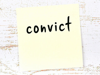 Yellow sheet of paper with word convict. Reminder concept