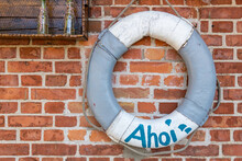 Life Ring With The Inscription AHOI On A Brick Wall