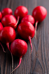 Red bright radish on dark wooden background, macro catalogue shot