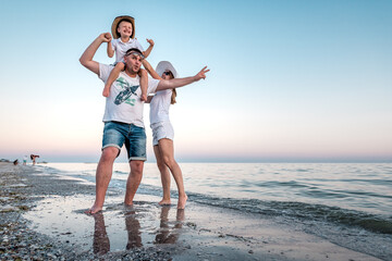 young family posing on the beach