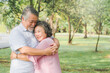 © Pormezz - Happy asian elderly couple hugging together in the park