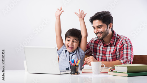Online school in India concept - Cute little son taking father\'s help in studies or homework