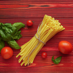 Bunch of tagliatelle on a red wooden background