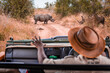© Marek - Safari guide in jeep with calming sign looking at rhinos in the wild