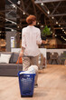 © mad_production - Vertical rear view shot of a woman walking in furniture store with a cart