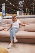 © mad_production - Vertical shot of a mature attractive woman sitting on a couch at furniture store