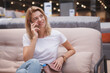 © mad_production - Mature housewife talking on the phone resting on a sofa at furniture store