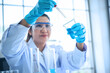 © sutlafk - Asian female tech or scientist loads blue liquid sample into test tube with plastic pipette. Shallow DOF, focus on the hand with the tube. Asia scientist woman making research biology in laboratory.