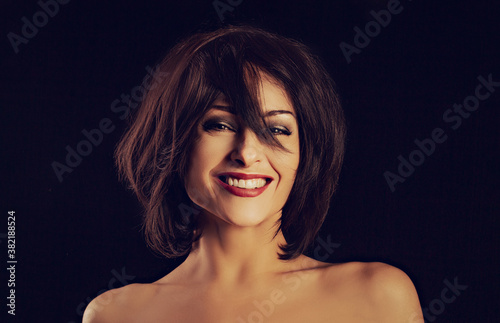 Cuadros en Lienzo Beautiful happy laughing bright makeup woman shaking her black short hair on black background