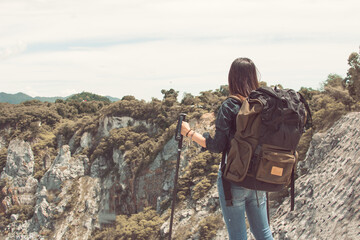 A woman standing on the top of mountain