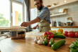 © Svitlana - Young man, Italian cook cutting vegetables and putting them in a pot while preparing healthy meal, soup in the kitchen. Italian cuisine concept