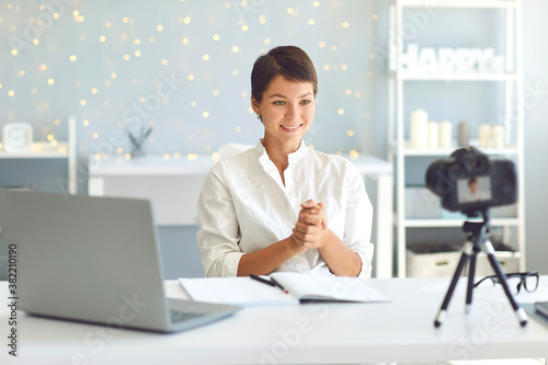 Cuadros en Lienzo Happy young female vlogger recording video for followers sitting at desk in cozy