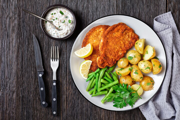 Wall Mural - German pork schnitzel with potato and green beans