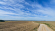 © kyrychukvitaliy - Autumn rural scenery of the dirt road running through cultivated agricultural fields, background of amazing blue sky. Copy space.