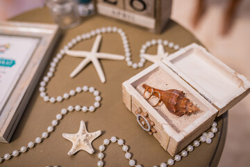 Poster - Close up view of wedding rings on the shell inside wooden box on the table with decor of pearls and shells, Punta Cana, Dominican Republic 