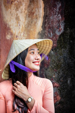 A Young Vietnamese Woman In A Traditional Ao Dai Dress And Conical Hat And Smiling, Hue, Vietnam