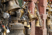 Old Cast Iron, Copper And Bronze Bells Held Together With Metal Chains And Locks.