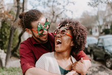 A Young Mixed Race Couple Walking Down The Street During Christmas Time.