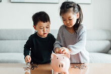 Family Saving Money In A Piggybank